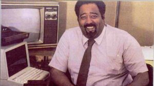 Gerald (Jerry) Lawson sitting at a desk with an old fashion Television set. 