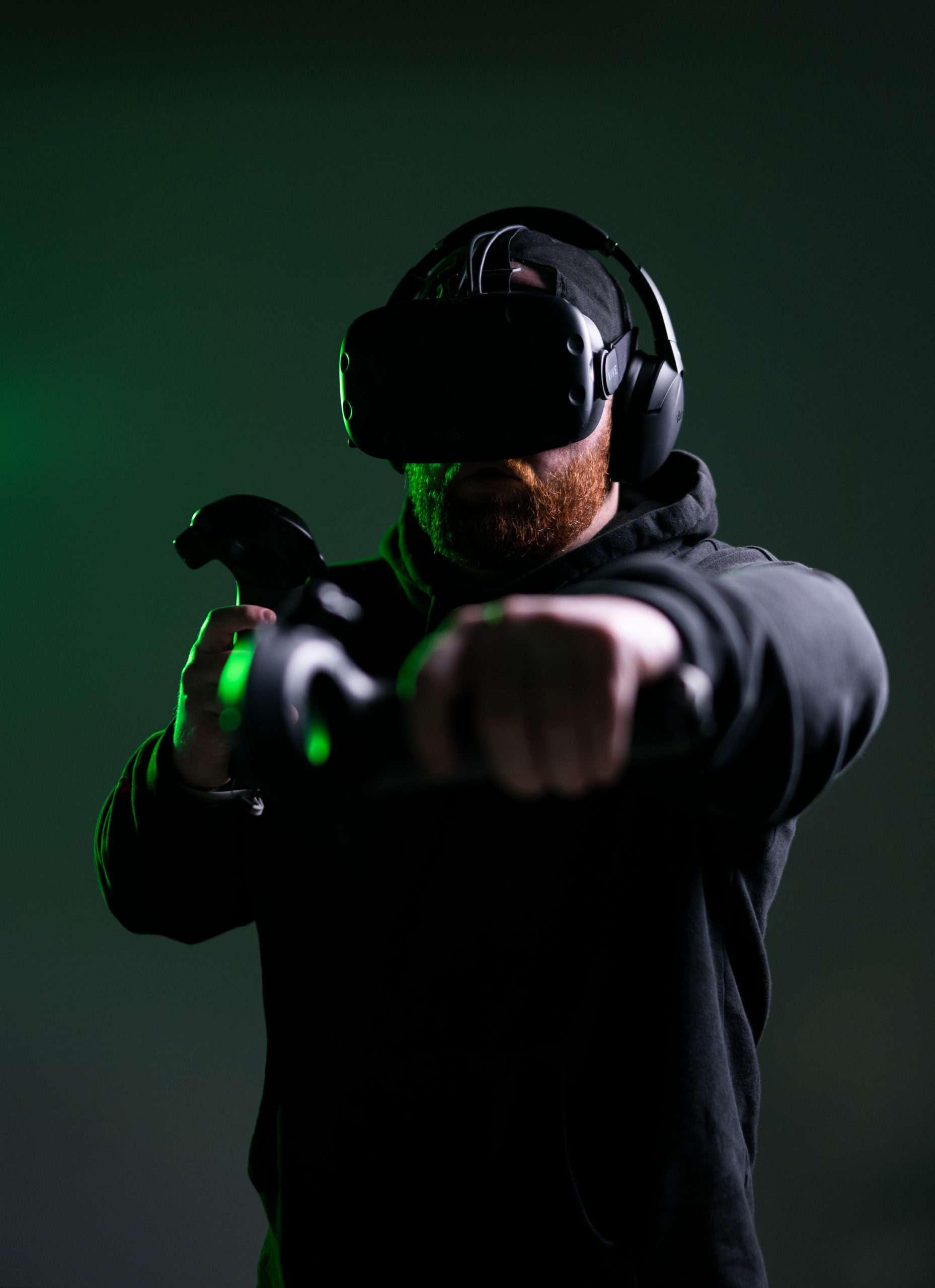Man wearing VR headset and gloves in dark green lighting